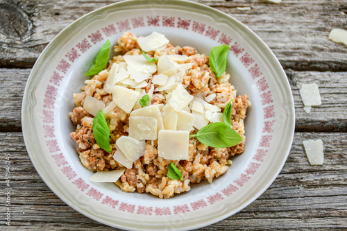 Italian bolognese risotto with parmesan cheese on rustic background