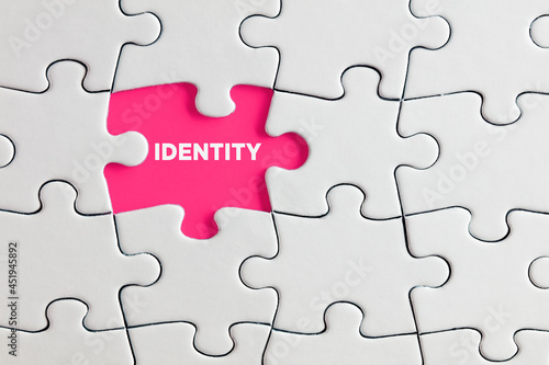 The word identity written on pink missing puzzle piece. Individuality, difference or diversity