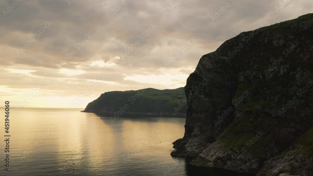 Sea Cliff Near The Town Of Maloy In Vagsoy Island, Norway On A Cloudy Sunset. orbiting shot Sea Cliff Near The Town Of Maloy In Vagsoy Island, Norway On A Cloudy Sunset. orbiting shot