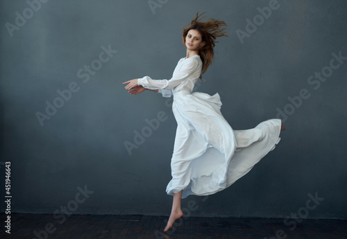 pretty woman dancing in white dress studio isolated background fashion