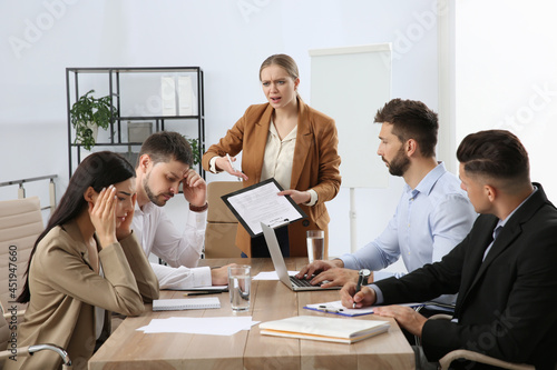 Boss screaming at employees in office. Toxic work environment photo