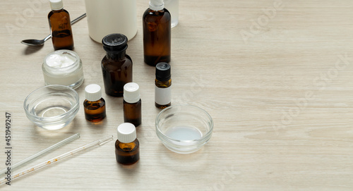 Brown glass bottles of oils,natural pieces on the wooden lab table for cosmetic development.Empty space