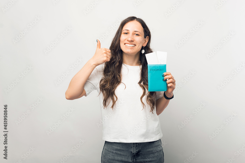 Young smiling woman is holding her passport and flight tickets. Young smiling woman is holding her passport and flight tickets.
