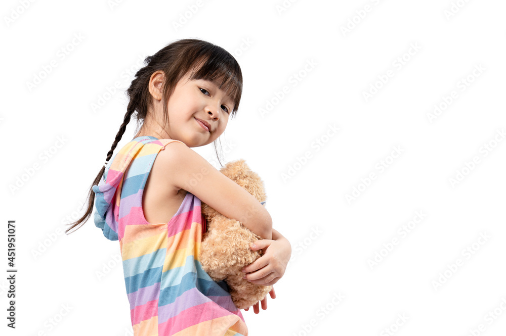 Cute little Asian girl hugging her favourite brown teddy bear and smiling in white background. girl and doll, favorite toy, happy child Cute little Asian girl hugging her favourite brown teddy bear and smiling in white background. girl and doll, favorite toy, happy child