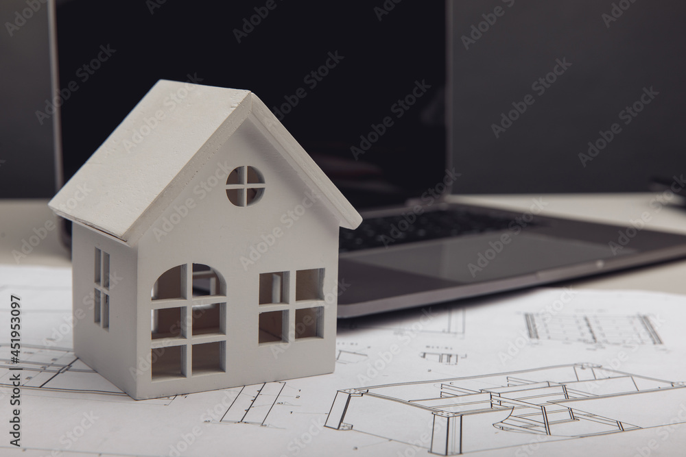 Model of house and laptop on drawing. Building and architect concept Model of house and laptop on drawing. Building and architect concept