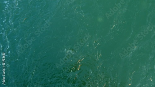 Ship's bow moving through blue water sea waves Overhead view from forecastle deck. Aerial view 4K Never endless turquoise ocean surface.