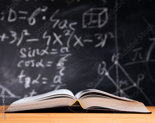 Open book on the table with blackboard background