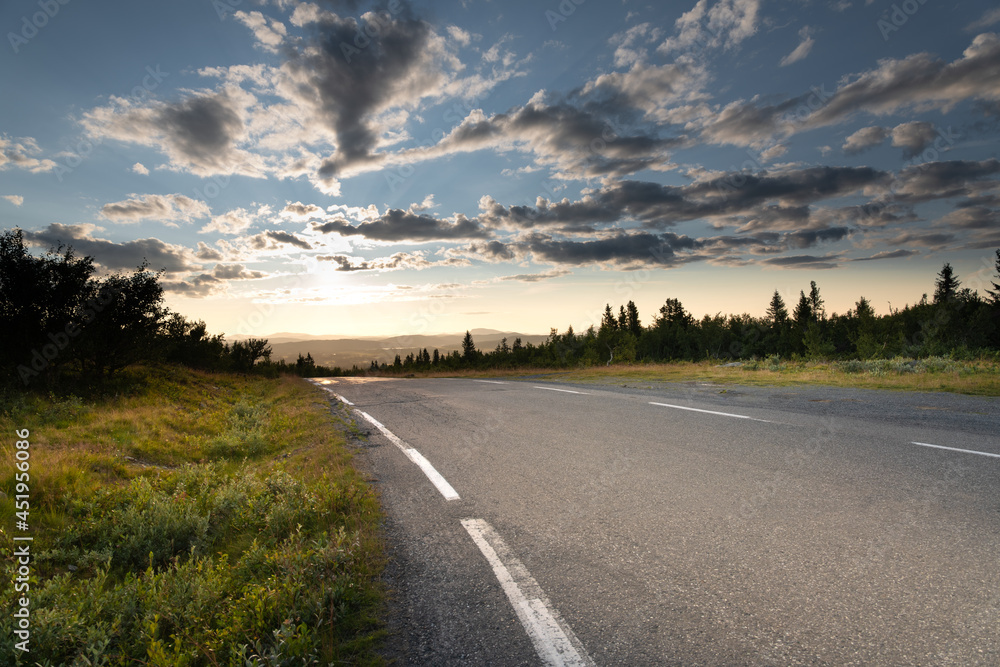 Mountain road driving into the sunset