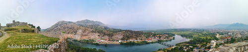 Fototapeta Naklejka Na Ścianę i Meble -  Panorama of the Buna river valley - view from the wall of the Shkoder castle (Albania). Beautiful widescreen landscape with the ruins of an ancient fortress, mountains, plain, river and city