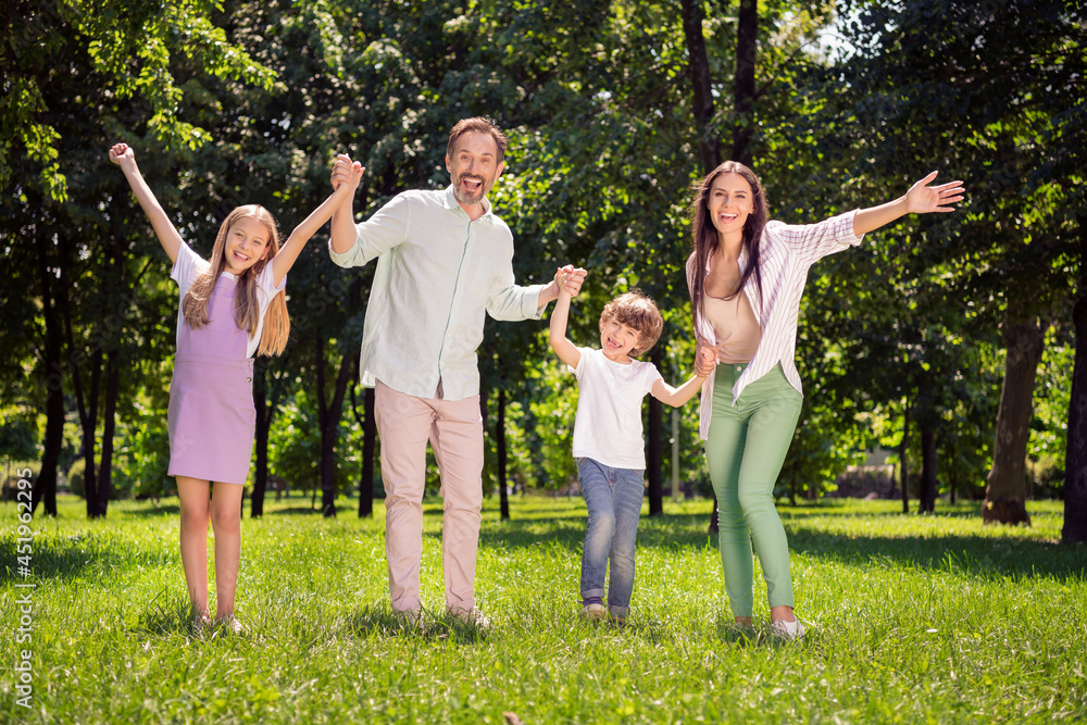 Obraz premium Photo of funny excited father mother school girl boy wear casual clothes walking holding arms smiling outdoors countryside forest