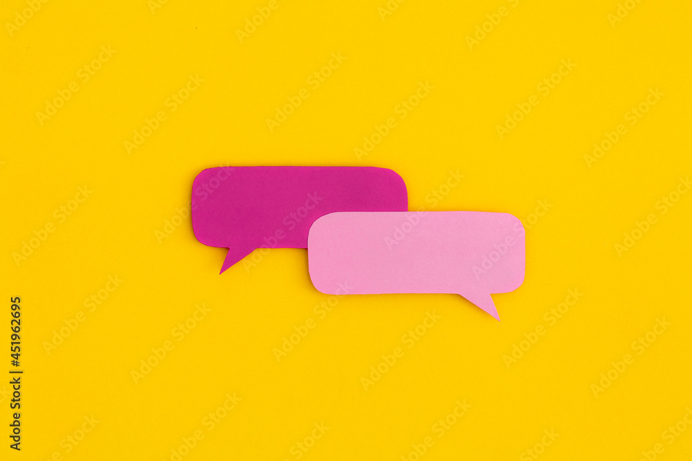 Paper speech bubbles on a yellow background. Top view with copy space. Flat lay.