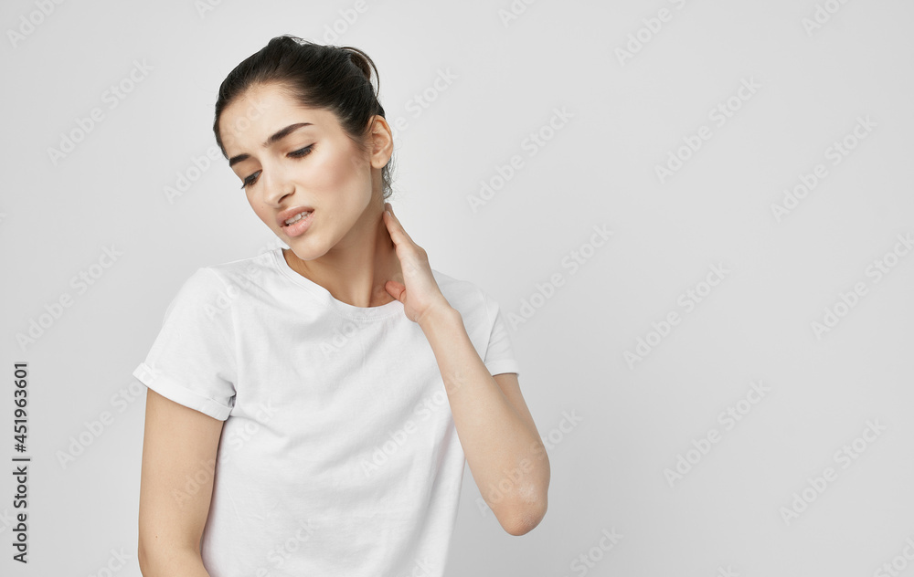 brunette in a white t-shirt holds on to the neck treatment brunette in a white t-shirt holds on to the neck treatment