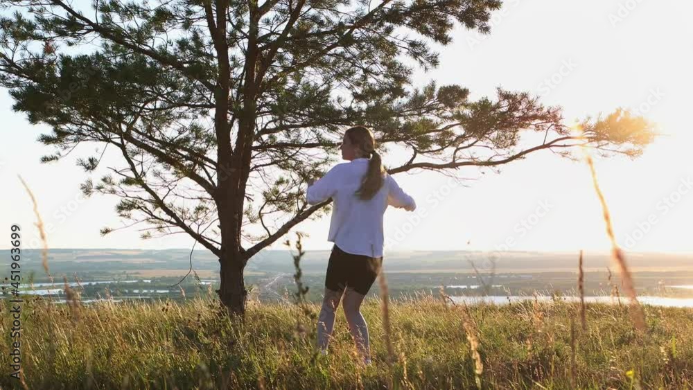 Swords training - young pretty woman in white shirt waving with a sword outdoors at early sunset on nature Swords training - young pretty woman in white shirt waving with a sword outdoors at early sunset on nature