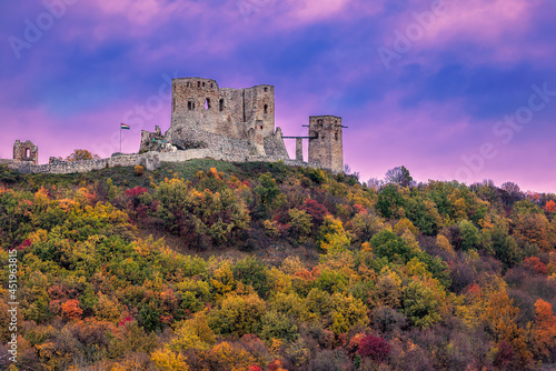 Purple sunset above the ruins of the medieval Csesznek Castle in the Bakony Mountain, Hungary during the autumn photo