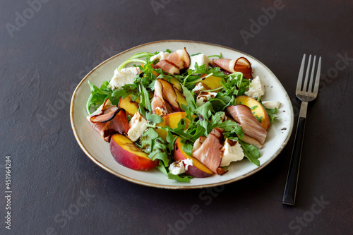 Salad with peaches, arugula, cheese and jamon. Healthy eating.