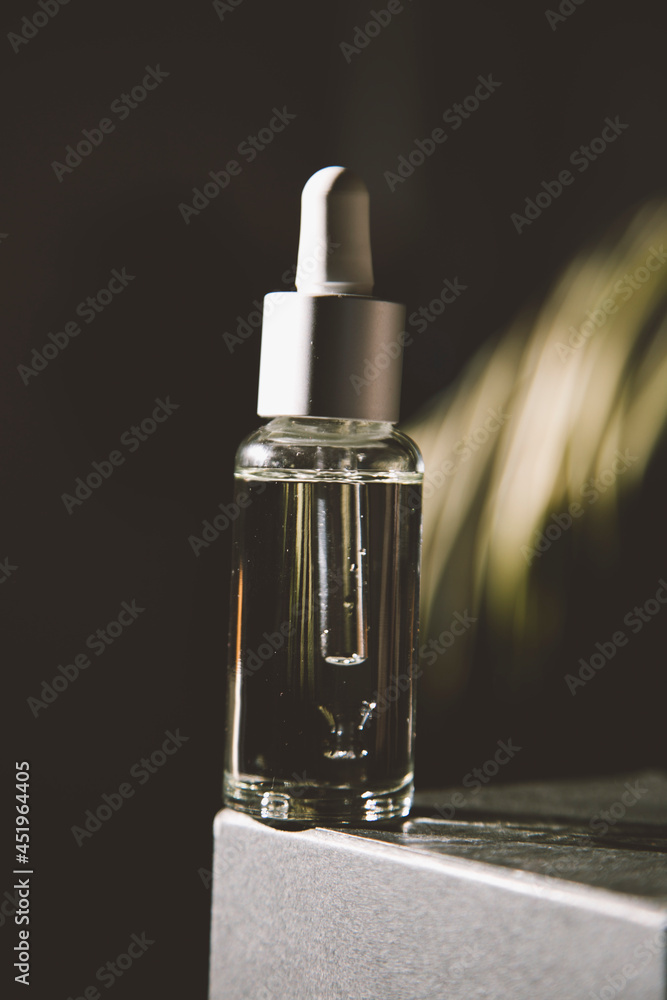 Serum in a glass bottle with a pipette. Essential oil for the care of women's skin. Skin care, moisturizing cosmetic product. Serum in a glass bottle with a pipette. Essential oil for the care of women's skin. Skin care, moisturizing cosmetic product.