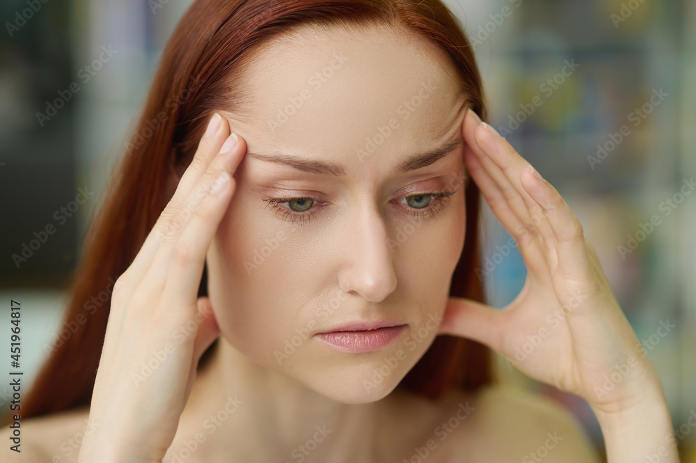 Sad adult pretty woman suffering from a temporal pain Sad adult pretty woman suffering from a temporal pain