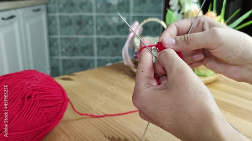 Close up of hands knitting. Lifestyle shot of at home crafting, making a garment from wool.