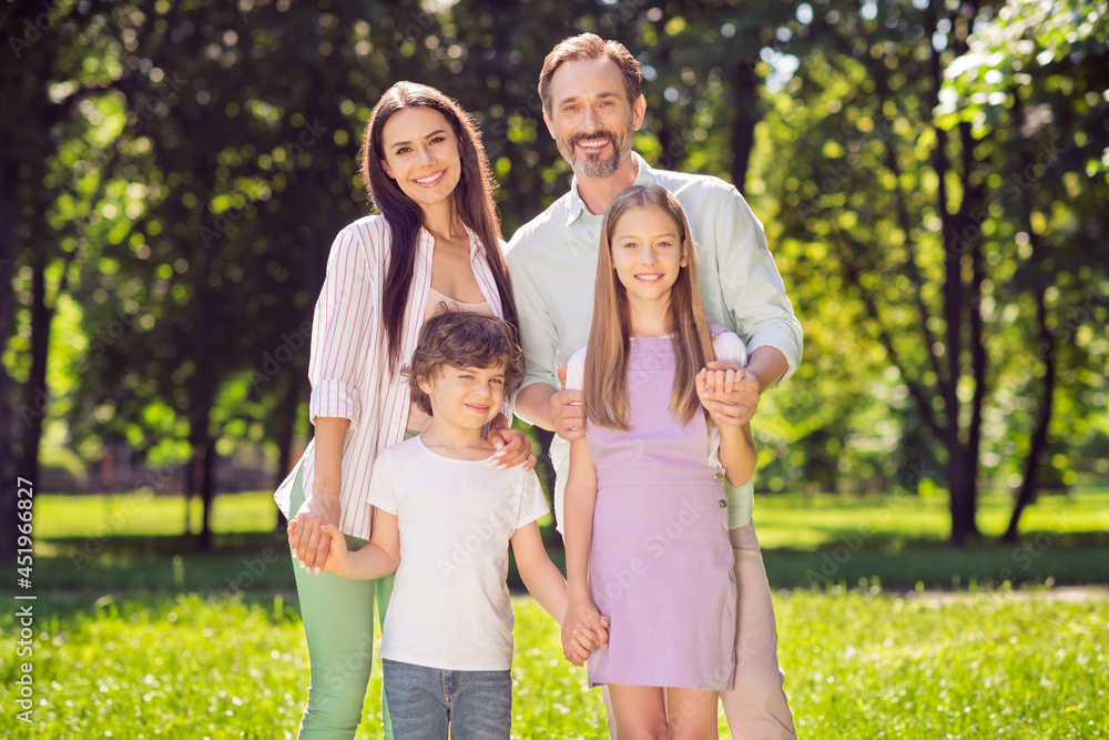 Fototapeta premium Portrait of attractive adorable cheerful family dad daddy hugging mom mommy spending time on fresh air outdoors