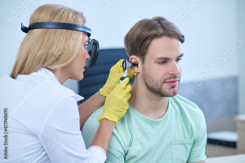 Photography Doctor performing an otoscopic examination of the patients auditory canal