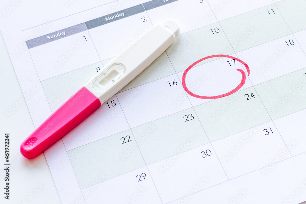 Calendar with pregnancy test, top view. Morherhood and pregnancy concept Calendar with pregnancy test, top view. Morherhood and pregnancy concept