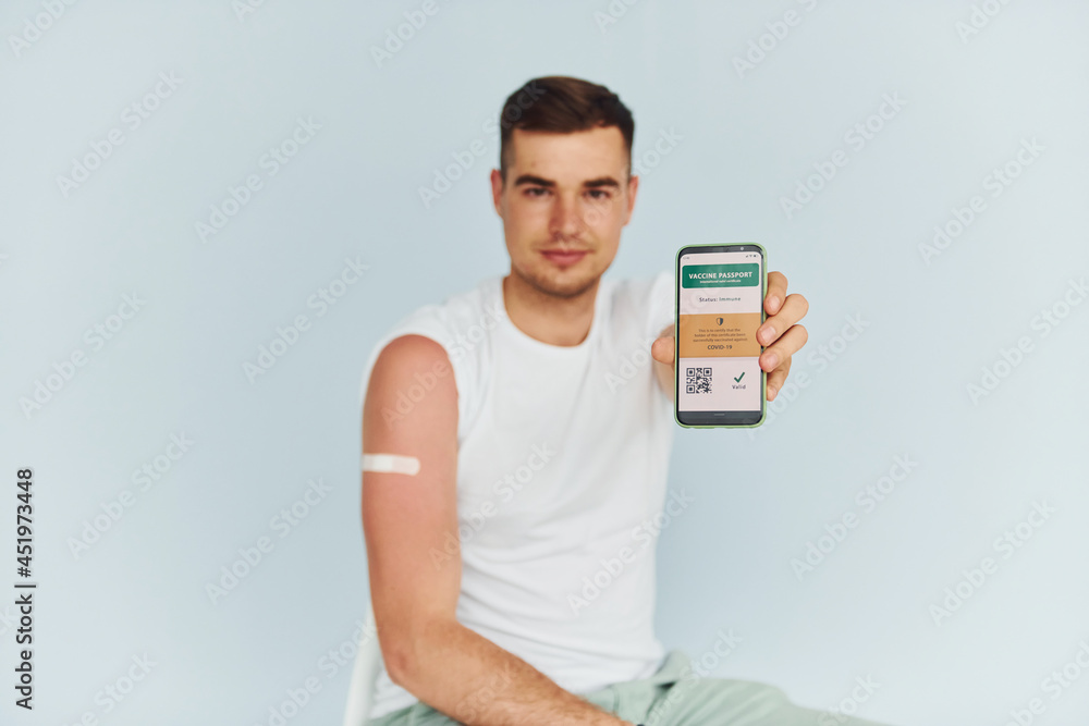 Young man in white shirt is indoors against white background Young man in white shirt is indoors against white background