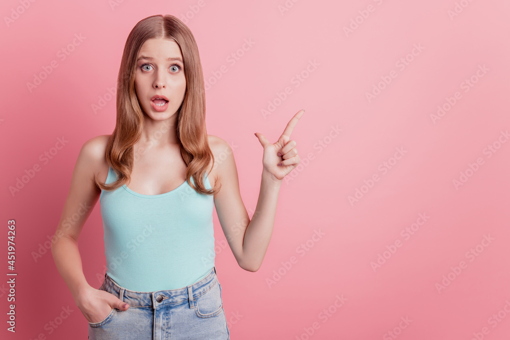 Portrait of girlish promoter reliable lady open mouth direct finger empty space on pink background Portrait of girlish promoter reliable lady open mouth direct finger empty space on pink background
