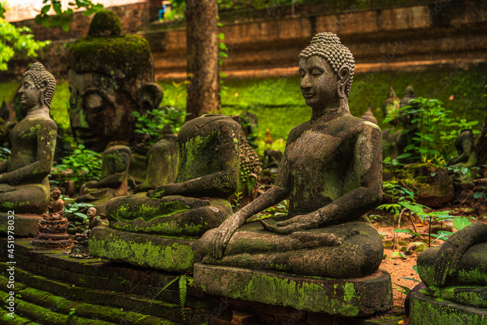 Ancient buddha figures Wat Umong Suan Puthatham is a Buddhist temple in the historic centre and is a Buddhist temple is a major tourist attraction with green forest nature in Chiang Mai,Thailand. - obrazy, fototapety, plakaty 