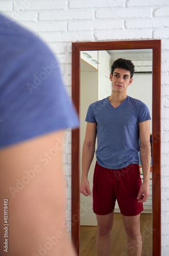 young man smiling because he likes what he sees in the mirror