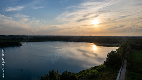 Aerial view shot by a drone of a beautiful dramatic and colorful sunset at coast of the lake. Nature landscape. Nature in Europe. reflection  blue sky and yellow sunlight. landscape during sunrise or