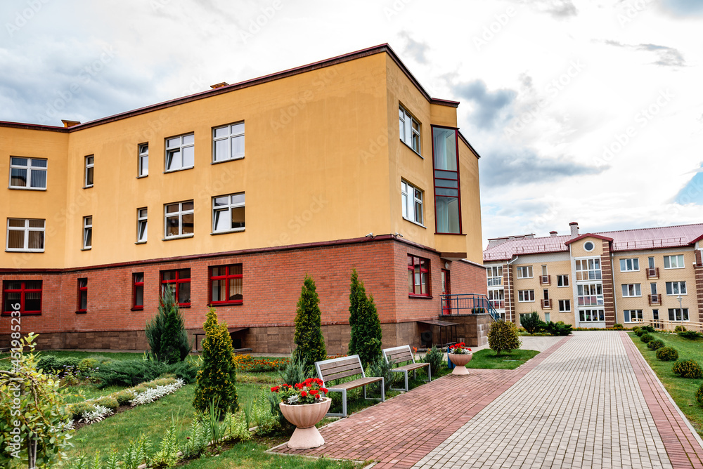 Exterior view of modern public school building with playground.