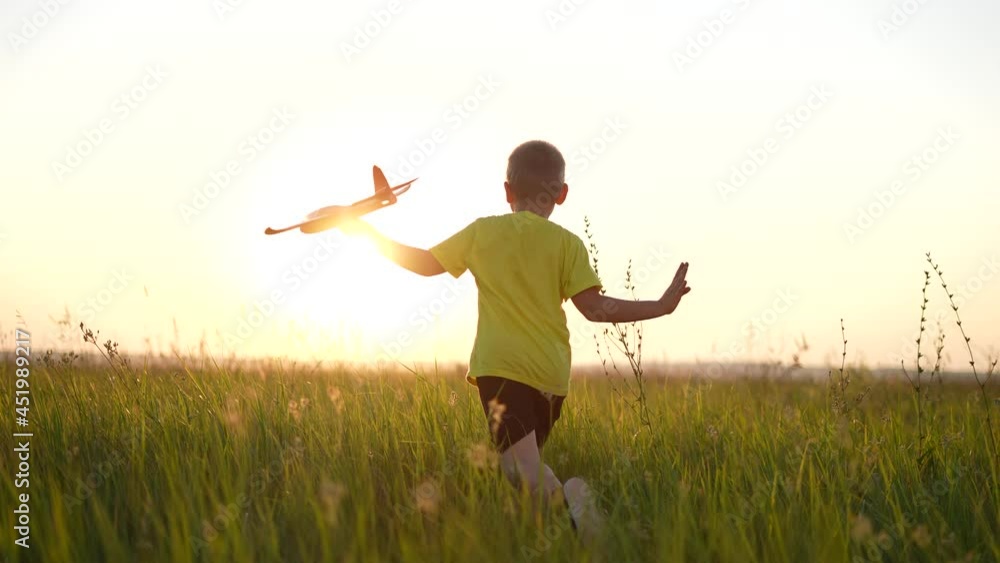 child runs with silhouette toy airplane in park field. childhood kid dream happy family concept. boy running with toy airplane in the park at sunset. boy kid play dream of becoming a sunlight pilot child runs with silhouette toy airplane in park field. childhood kid dream happy family concept. boy running with toy airplane in the park at sunset. boy kid play dream of becoming a sunlight pilot