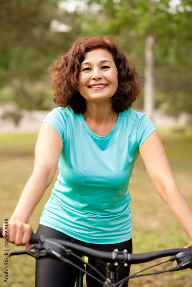 Middle age senior woman on bike cycle ride in countryside park outdoor Middle age senior woman on bike cycle ride in countryside park outdoor