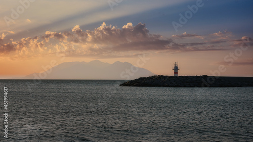 lighthouse and beach with clouds at island port