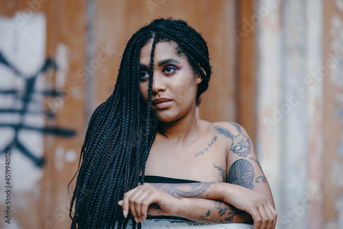 Portrait of a young beautiful tattooed girl with box braids hairstyle photo