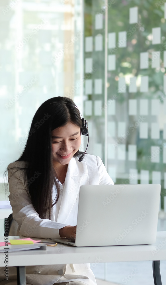 Young woman using headset and computer laptop while talking with customers online. Young woman using headset and computer laptop while talking with customers online.