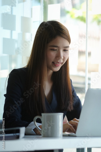 Beautiful businesswoman working with laptop in modern office.. © wattana