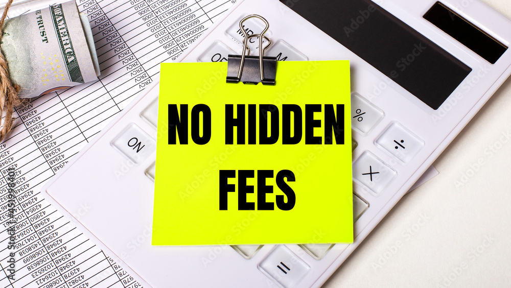 On a light background - cash, a white calculator and a yellow sticker under a black paper clip with the text NO HIDDEN FEES. Business concept On a light background - cash, a white calculator and a yellow sticker under a black paper clip with the text NO HIDDEN FEES. Business concept