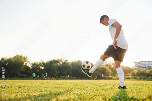 Doing different tricks. Young soccer player have training on the sportive field