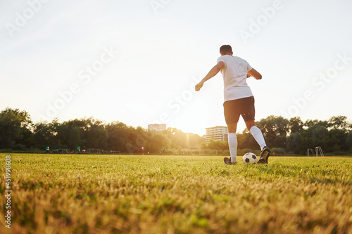 Runs with ball. Young soccer player have training on the sportive field