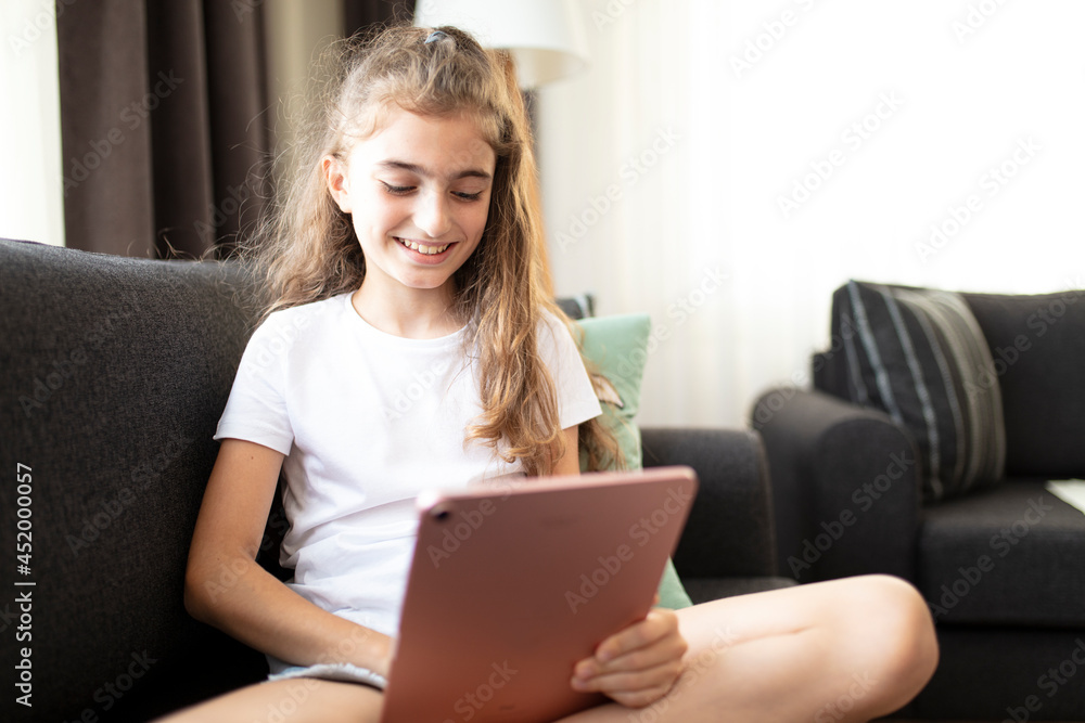 Portrait of a happy teenage girl using digital tablet in home. Portrait of a happy teenage girl using digital tablet in home.