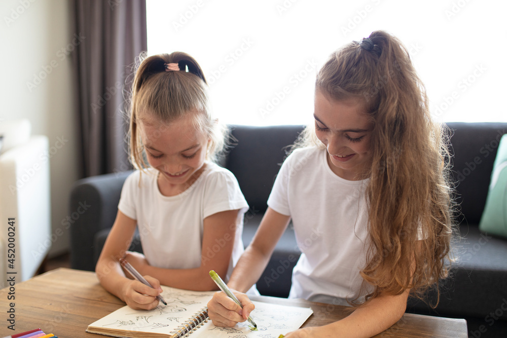 two sisters having a good time at home. children doing creative art work. two sisters having a good time at home. children doing creative art work.