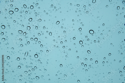 Water rain drop on glass liquid splashing wet glass surface with rainy season.