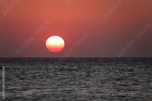 Fototapeta Naklejka Na Ścianę i Meble -  orange sunset over the sea. A great view of the sun over the sea on Imbros island at orange sunset . Gökçeada sunset view