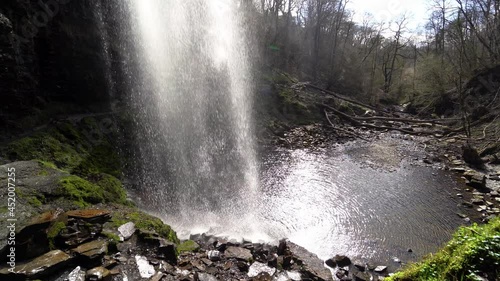 Water cascading down Henrhyd falls on a sunny afternoon. Brecon Beacons National Park, Wales, the United Kingdom photo