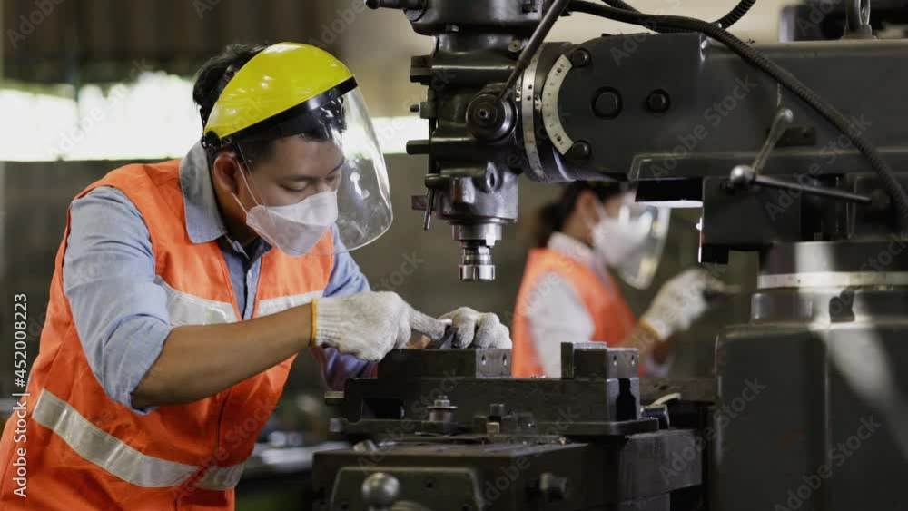 Team Asian Machine engineer wearing face shield work active in factory Industry. using face mask protect COVID-19 while working Safety while working with machines. Intention to work professionally Team Asian Machine engineer wearing face shield work active in factory Industry. using face mask protect COVID-19 while working Safety while working with machines. Intention to work professionally