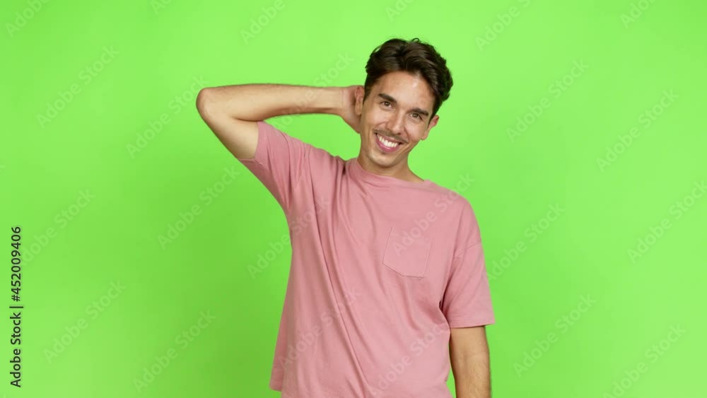Young man posing with arms at hip and laughing over isolated background. Green screen chroma key Young man posing with arms at hip and laughing over isolated background. Green screen chroma key