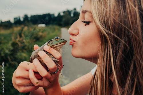 girl about to kiss a frog 