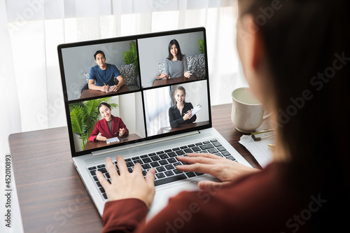 Young businesswoman work at home and virtual video conference meeting with colleagues business people, online working, video call due to social distancing concept.