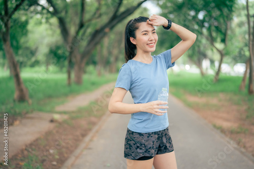 Asian women drink water after exercising